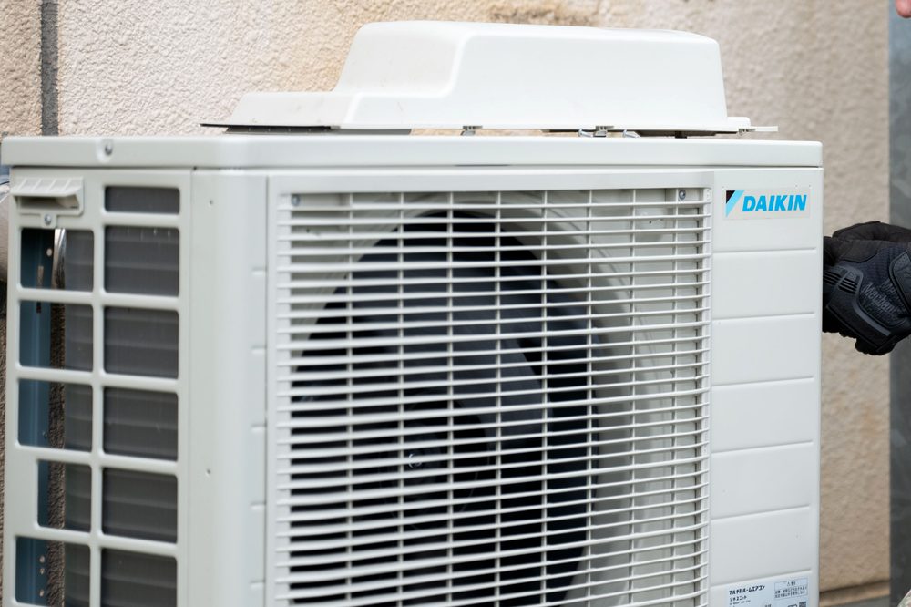 Technician installing a new outdoor air conditioning unit